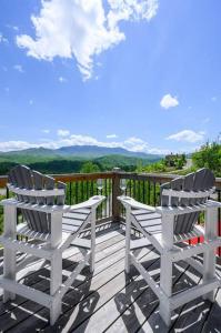 two white chairs sitting on top of a deck at Modern Cabin near Smoky Mountain National Park in Gatlinburg