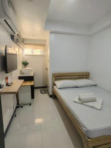 a bedroom with a bed and a desk and a sink at AA TRAVELLERS PAD in Laoag