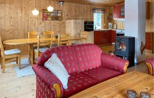 - un salon avec un canapé rouge et une cuisinière dans l'établissement 3 Bedroom Nice Home In Bjorli, à Bjorli
