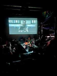 a man on a screen in front of a audience at Easy Tiger Garden Bungalows - by Beach House Cambodia in Koh Rong Sanloem