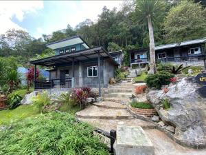 a house with a blue roof and stairs to it at ม่านฟ้าฮิลล์ ภูชี้ฟ้า 