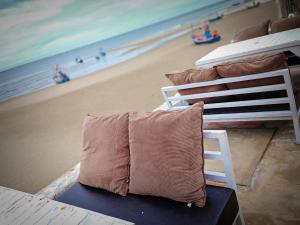 a pillow sitting on a bed next to a beach at The Room Arun in Hua Hin