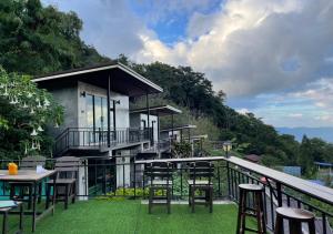ein Haus mit einem Balkon mit Stühlen und einem Tisch in der Unterkunft Ban Rabiengfah Resort in Ban Seng Choi