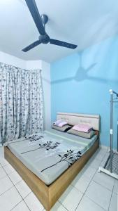 Ce lit se trouve dans un dortoir doté d'un ventilateur de plafond. dans l'établissement Edaman Guest House, à Kota Kinabalu