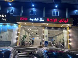 a store with cars parked in front of it at night at ليالي الراحة للوحدات السكنية in Taif