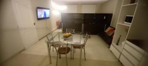 una camera con tavolo, sedie e frigorifero nero di Confortable y Amplio loft a Mendoza