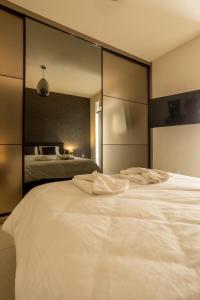a bedroom with two beds and a large mirror at AIOLOS GLYFADA luxury sea view suite 5 in Athens