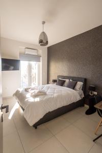 a bedroom with a large bed and a large window at AIOLOS GLYFADA luxury sea view suite 5 in Athens