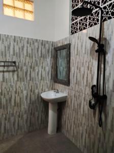 La salle de bains est pourvue d'un lavabo et d'un miroir. dans l'établissement Private house, à Ubud