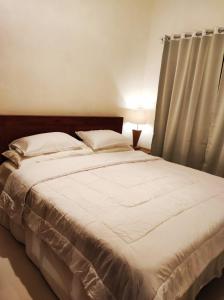- une chambre avec un grand lit blanc et une fenêtre dans l'établissement Private house, à Ubud