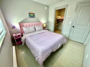 a bedroom with a pink bed with a pink headboard at Brand new Apartment with Extra Sofa Bed, air conditioning, 15 mins to Alki Beach and Downtown Seattle and 19 mins to SeaTac Airport in Seattle