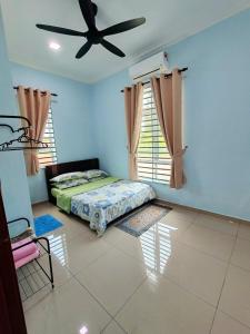 MerlimauにあるHomestay Restu Mak Abah Private Pool Melakaのベッドルーム1室(ベッド1台、シーリングファン付)