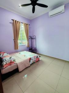 a bedroom with a bed and a ceiling fan at Homestay Restu Mak Abah Private Pool Melaka in Merlimau