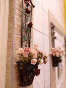 a vase of pink flowers hanging from a wall at YuanWai in Wujie