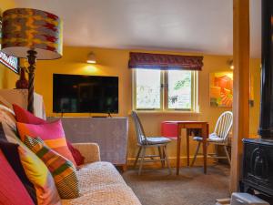 ein Wohnzimmer mit einem Sofa und einem Tisch mit Stühlen in der Unterkunft Owls Nest in Stradbroke