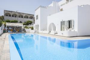 a large swimming pool with white buildings in the background at Nissos Thira in Fira