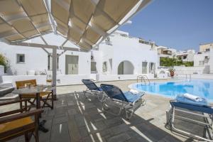 a patio with chairs and a swimming pool at Nissos Thira in Fira