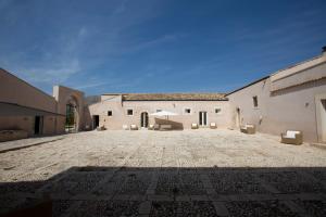 un gran patio de un edificio con suelo de piedra en Ballium Luxury Relais, en Avola