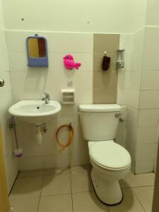 een badkamer met een toilet en een wastafel bij IRDINA HOMESTAY - Changlun, Kedah in Changlun