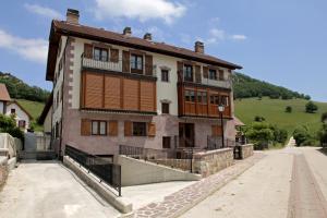 an old building with a hill in the background at Apartamentos Irati Garralda in Garralda