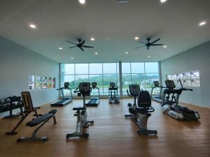 a gym with treadmills and exercise equipment in a room with windows at Wyattcamp @ mahkota valley in Kuantan