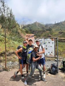 a group of people posing for a picture on a mountain at Mount Rinjani Guest House in Sajang