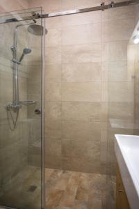 a shower with a glass door in a bathroom at AIOLOS GLYFADA luxury sea view suite 5 in Athens