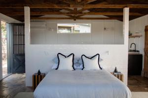 a bedroom with a large white bed with two pillows at Log Box Red Hill in Red Hill South