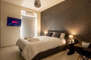 a bedroom with a large white bed with a clock on the wall at AIOLOS GLYFADA luxury sea view suite 5 in Athens