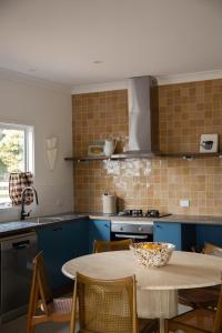 a kitchen with blue cabinets and a table with chairs at Log Box Red Hill in Red Hill South