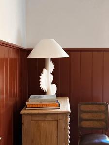 a lamp sitting on top of a table with books at Log Box Red Hill in Red Hill South
