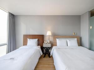 Postel nebo postele na pokoji v ubytování Haeundae Seacloud Hotel Residence