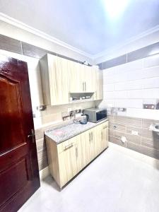 uma cozinha com armários de madeira e um lavatório em Maison de repos em New cairo