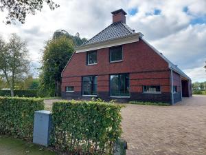 una gran casa de ladrillo rojo con techo en Smaakvol Slochteren en Slochteren