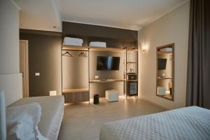 ein Hotelzimmer mit einem Bett und einem TV in der Unterkunft Castrichella Boutique Hotel Rome Airport in Fiumicino