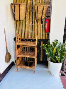 a porch with a wicker chair and a fence at Mano Residence esidence in Luang Prabang