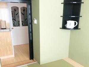 una habitación con una puerta con una taza de café en la pared en LIFT IN HAKUBA GORYU - Vacation STAY 71289v, en Iida