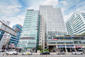 a city with cars parked in front of tall buildings at Haeundae Seacloud Hotel Residence in Busan