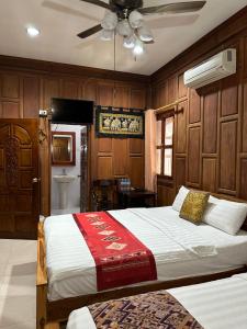 a bedroom with a bed and a ceiling fan at Mano boutique sun shine in Luang Prabang +41 photos