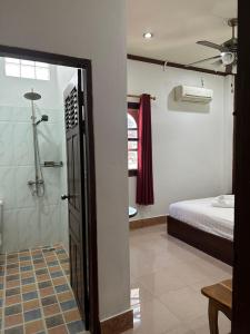 1 dormitorio con 1 cama y baño con ducha. en Mano boutique sun shine en Luang Prabang
