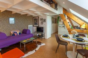 sala de estar con sofá púrpura y mesa en un Nid en Ville -Amiens Centre ville avec Parking, en Amiens