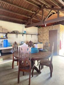 einen Holztisch und Stühle in einem Zimmer in der Unterkunft Maria Kulafu Kubo House 1 BIG BEDROOM with Wifi in Masbate