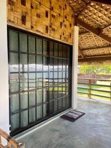 a building with a large glass door on a patio at Maria Kulafu Kubo House 1 BIG BEDROOM with Wifi in Masbate