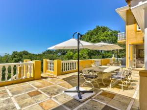 a patio with an umbrella and a table and chairs at Devonport House - Constantia in Cape Town