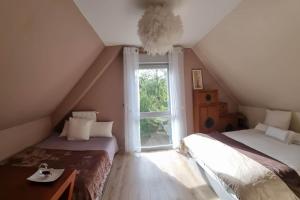 a attic room with two beds and a window at Villa des Climats Bourgogne in Marsannay-la-Côte