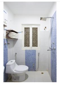 a bathroom with a toilet and a window and a shower at The Global Nomad Apt Centrally Located in Kathmandu