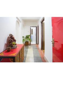 a hallway with a red door and a red table at The Global Nomad Apt Centrally Located in Kathmandu