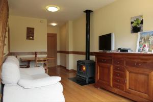 a living room with a white couch and a stove at Apartamentos Irati Olaldea in Oroz-Betelu