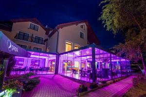 a glass building with purple lights in front of a building at Sailor Łeba in Łeba