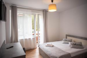 a bedroom with a bed and a large window at Casa Bucegi Busteni in Buşteni
